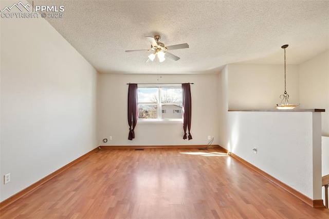 unfurnished room with ceiling fan, wood-type flooring, and a textured ceiling