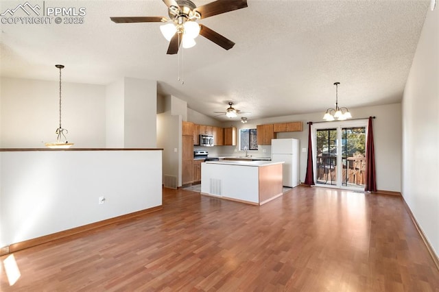 kitchen with stainless steel appliances, a kitchen island, dark wood-type flooring, and pendant lighting