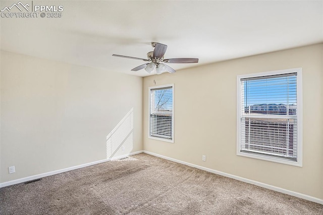 empty room featuring carpet flooring, a ceiling fan, and baseboards