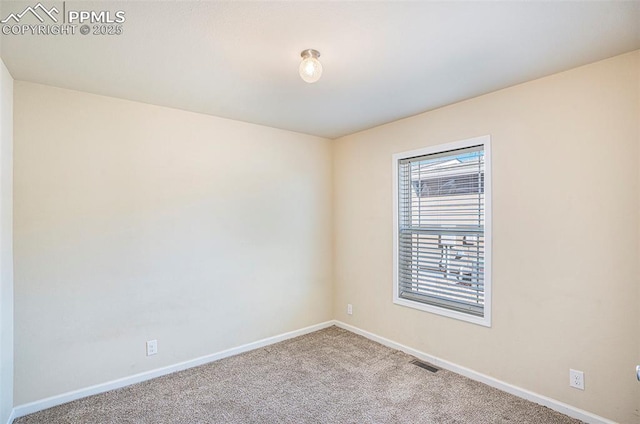 empty room featuring carpet, visible vents, and baseboards