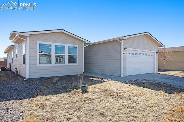 view of front of house featuring driveway, central AC, and an attached garage