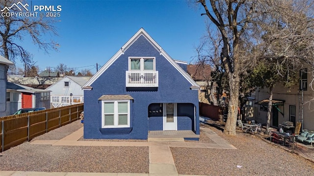 view of front of house featuring a patio area, a fenced backyard, and a balcony