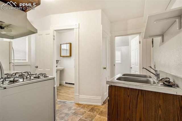 kitchen with island exhaust hood, a baseboard radiator, light countertops, a sink, and white appliances