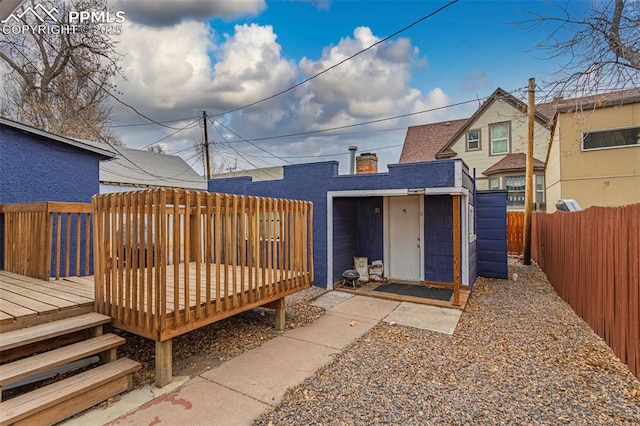 rear view of house with a fenced backyard and a wooden deck