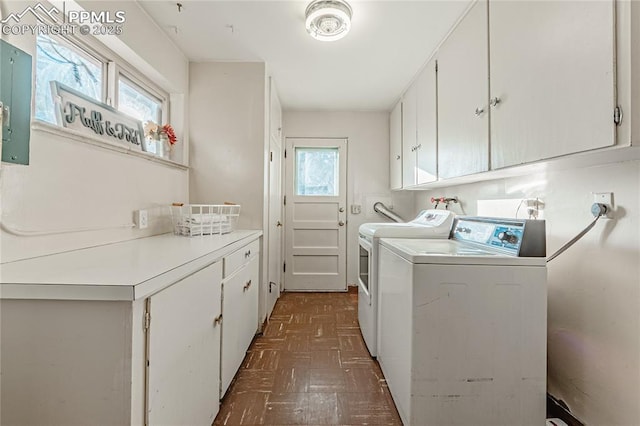 washroom featuring cabinets, a healthy amount of sunlight, and washer and dryer