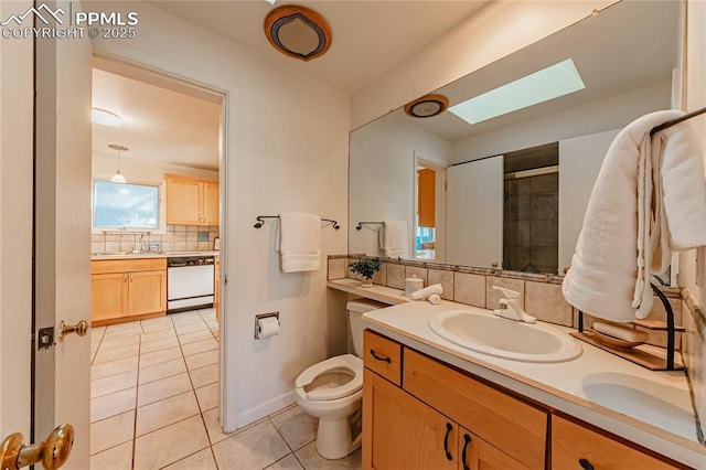 bathroom featuring a skylight, tasteful backsplash, tile patterned flooring, vanity, and toilet