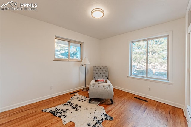 living area featuring hardwood / wood-style floors and a baseboard radiator