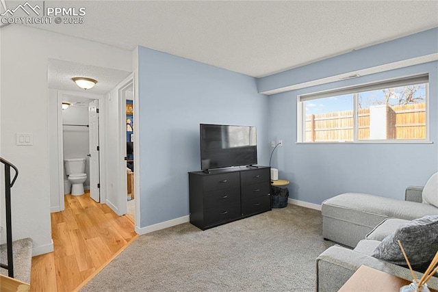 carpeted living room with a textured ceiling and baseboards