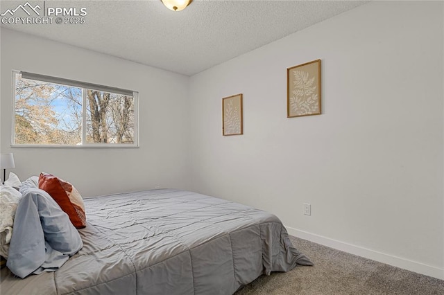 carpeted bedroom with a textured ceiling and baseboards