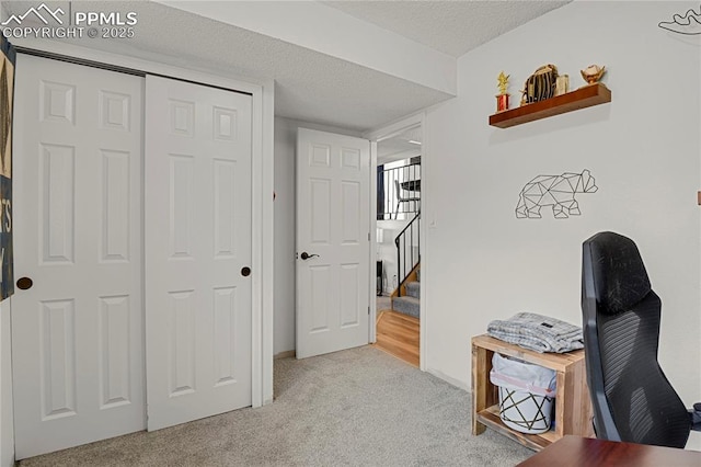 hall with carpet, stairway, and a textured ceiling