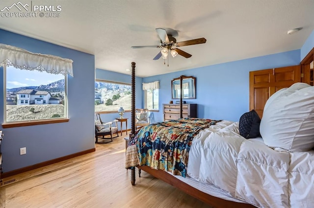 bedroom with visible vents, a ceiling fan, light wood-style flooring, and baseboards