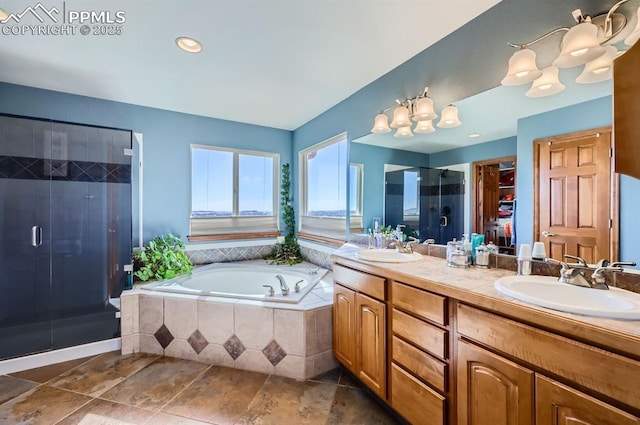 bathroom featuring a garden tub, a sink, a shower stall, and double vanity