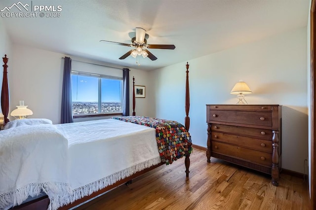 bedroom with wood finished floors, a ceiling fan, and baseboards