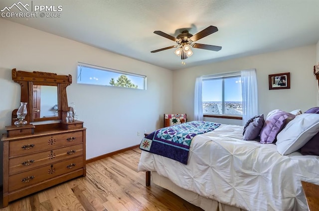 bedroom with light wood-style floors, ceiling fan, and baseboards