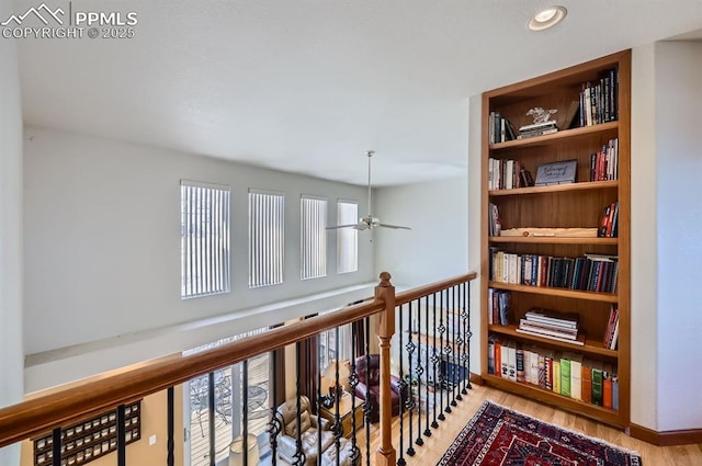 corridor featuring a wealth of natural light, baseboards, an upstairs landing, and wood finished floors