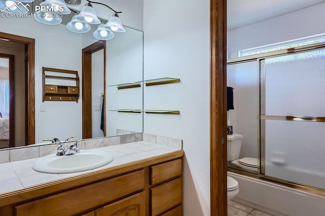 full bathroom with enclosed tub / shower combo, vanity, toilet, and tile patterned floors