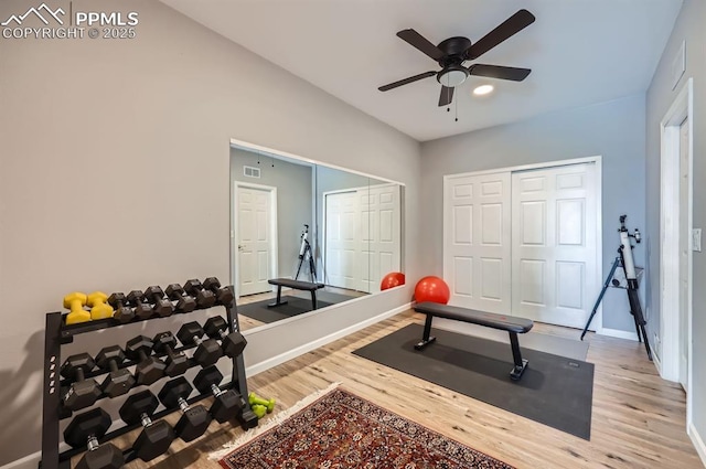 exercise area featuring visible vents, baseboards, ceiling fan, and wood finished floors