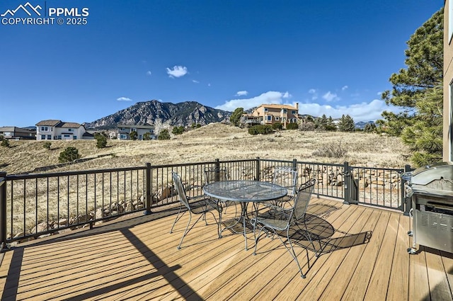 deck featuring outdoor dining space and a mountain view