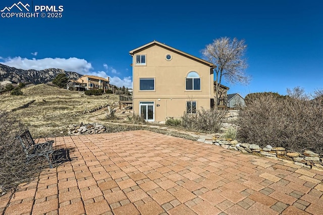 back of property with a patio area and stucco siding