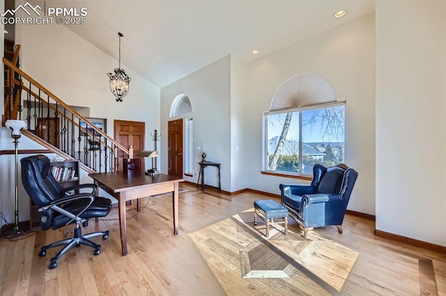 office featuring baseboards, wood finished floors, an inviting chandelier, high vaulted ceiling, and recessed lighting