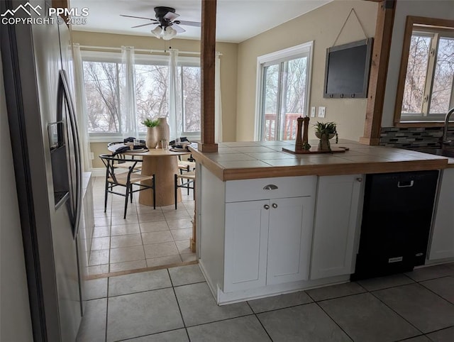 kitchen with light tile patterned floors, dishwasher, white cabinetry, tile counters, and stainless steel fridge with ice dispenser