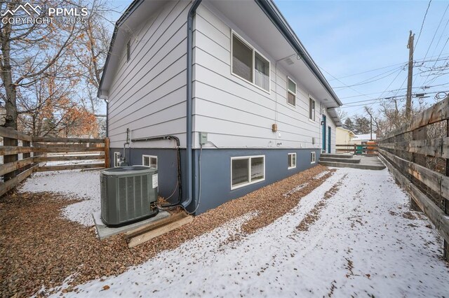 view of snowy exterior with central AC