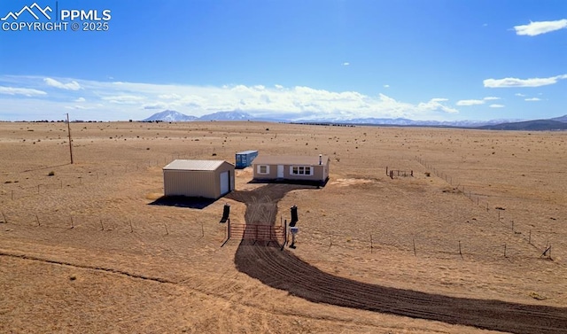 exterior space with view of desert, a storage unit, and a mountain view