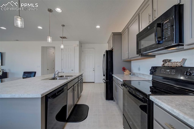 kitchen featuring sink, a center island with sink, gray cabinets, pendant lighting, and black appliances