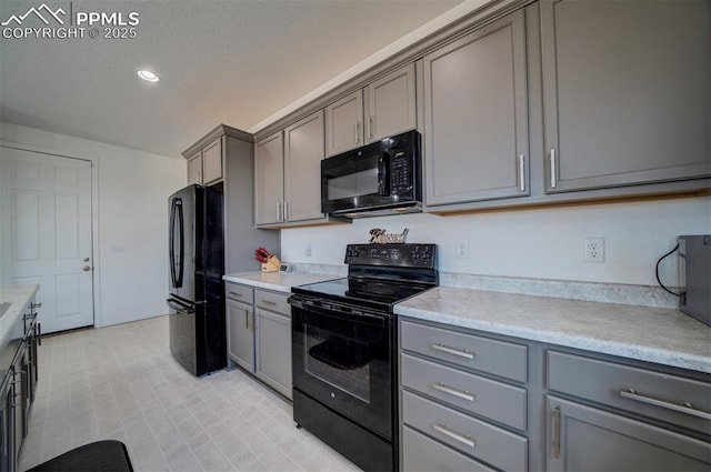 kitchen featuring gray cabinetry, a textured ceiling, and black appliances