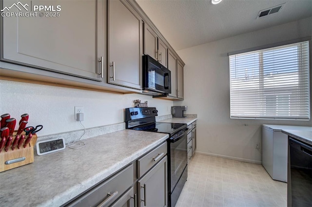 kitchen with a textured ceiling and black appliances