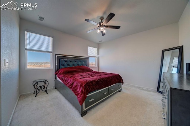 carpeted bedroom with ceiling fan and multiple windows