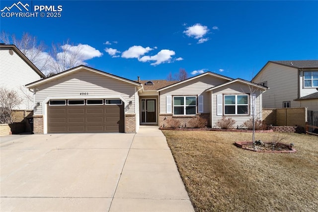 view of front facade featuring brick siding, concrete driveway, an attached garage, fence, and a front yard