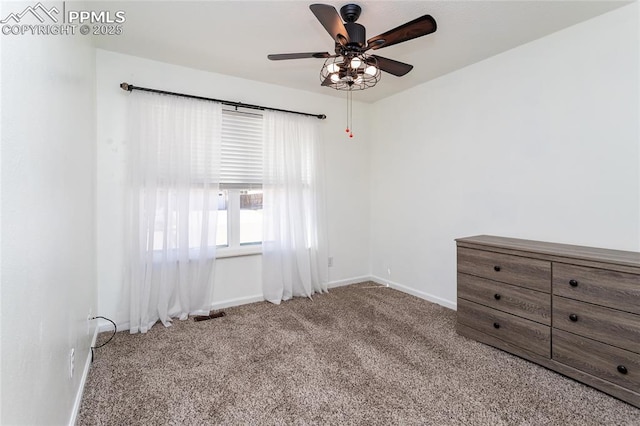 unfurnished room with a ceiling fan, baseboards, and carpet flooring