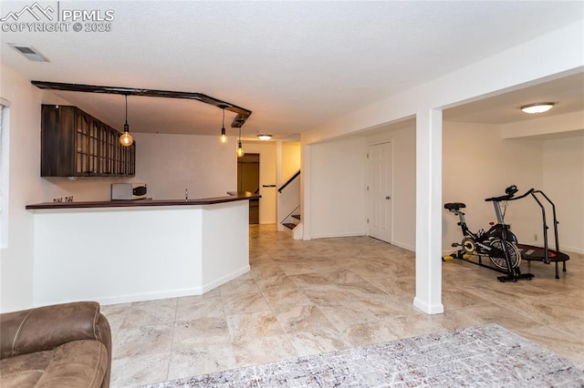 kitchen with dark countertops, visible vents, baseboards, and hanging light fixtures