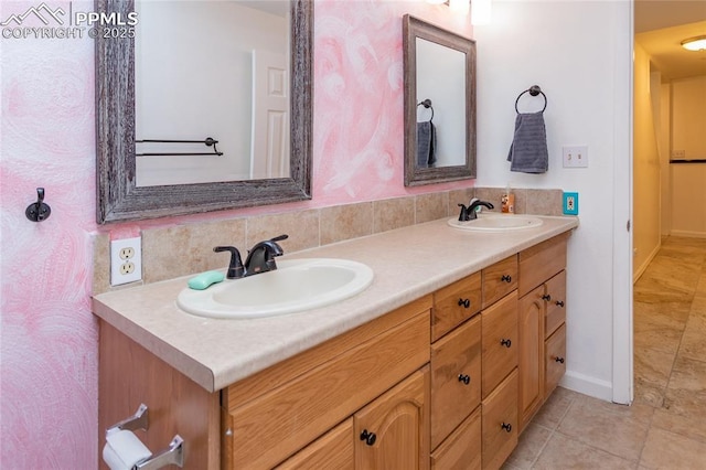 bathroom with tile patterned floors, a sink, backsplash, and double vanity