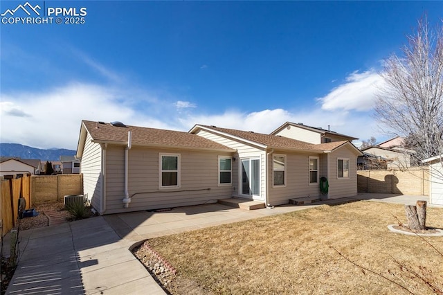 rear view of property with a fenced backyard, a lawn, and a patio