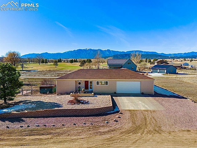 single story home with a garage and a mountain view