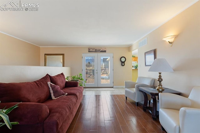 living room featuring ornamental molding, dark wood-type flooring, and french doors