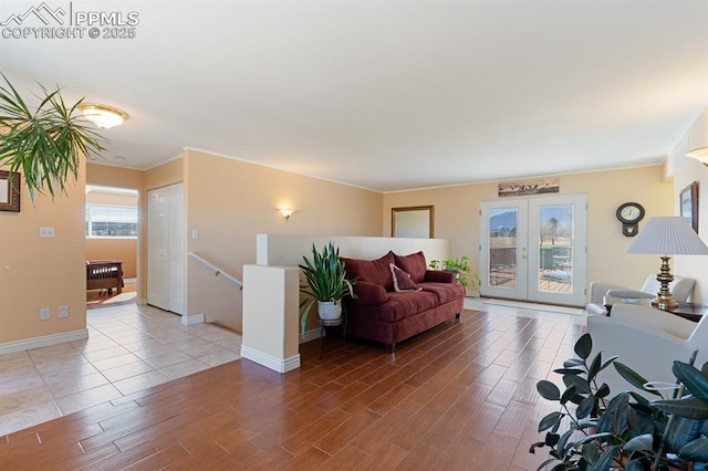 living room featuring ornamental molding, light hardwood / wood-style floors, and french doors