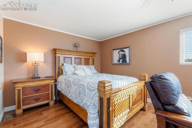 bedroom with crown molding and light hardwood / wood-style floors