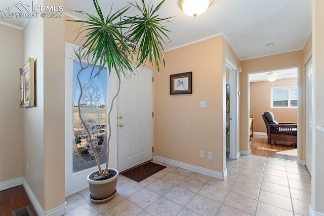 tiled entryway featuring crown molding