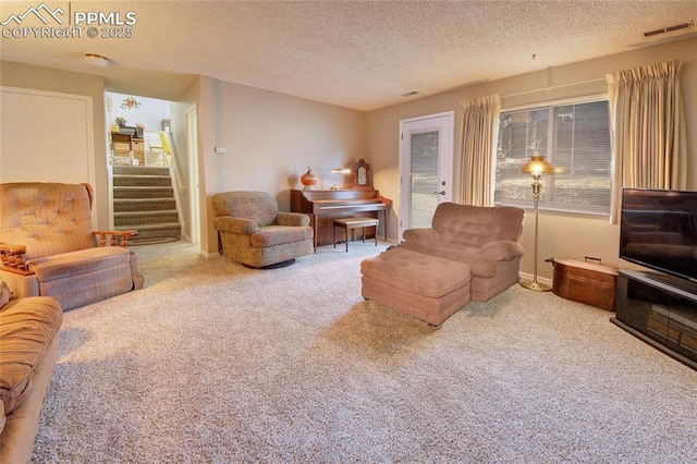 living room featuring carpet floors and a textured ceiling