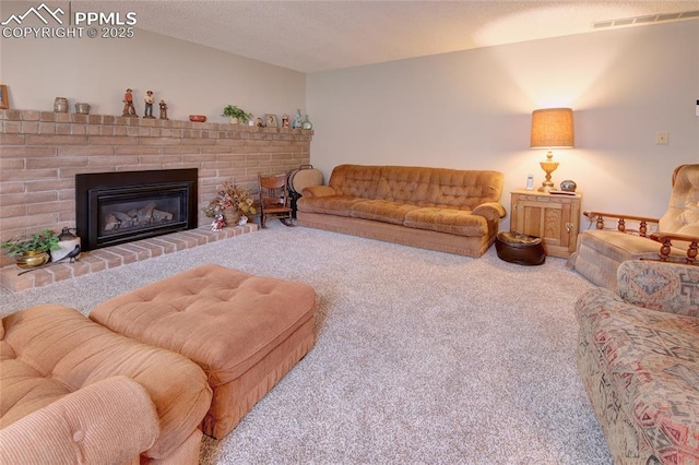 living room featuring a brick fireplace, carpet, and a textured ceiling