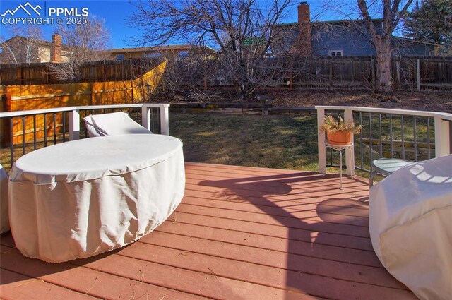 deck featuring grilling area and a lawn