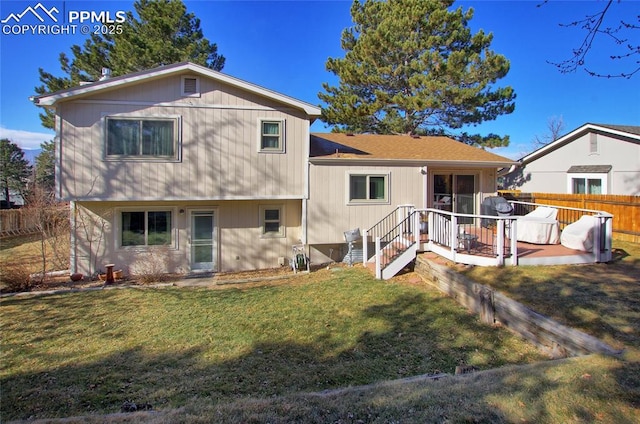 back of property featuring a wooden deck and a lawn