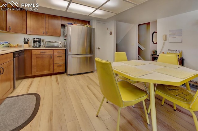 kitchen featuring stainless steel fridge, dishwashing machine, and light hardwood / wood-style flooring