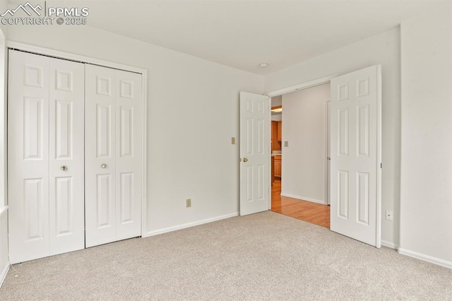 unfurnished bedroom featuring light colored carpet and a closet