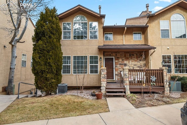 view of front of home with a front lawn, central air condition unit, and a deck