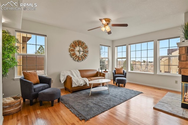 living room with ceiling fan, plenty of natural light, and light hardwood / wood-style floors