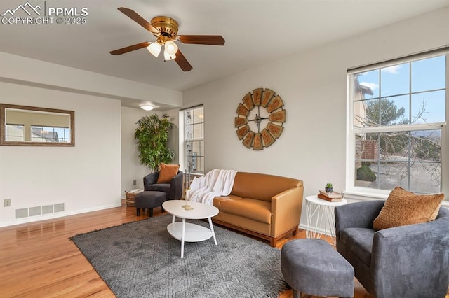 living room featuring wood-type flooring and ceiling fan